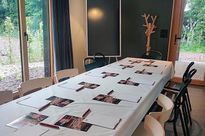 Vue d'une carrière avec des fleurs violettes au premier plan et une petite structure blanche en arrière-plan.