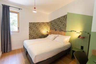 Vue d'une carrière avec des fleurs violettes au premier plan et une petite structure blanche en arrière-plan.