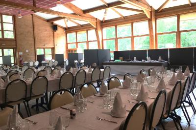 Chambre lumineuse avec lit double, mur décoré de papier peint à motifs végétaux et éclairage d'appoint.