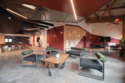 Chambre lumineuse avec lit double, mur décoré de papier peint à motifs végétaux et éclairage d'appoint.