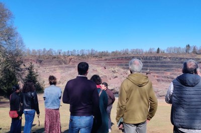 Paysage d'une ancienne carrière volcanique avec des formations rocheuses, entourée de végétation et sous un ciel bleu.