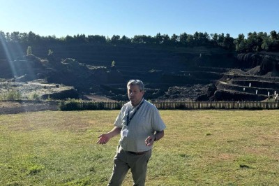 Paysage d'une ancienne carrière volcanique avec des formations rocheuses, entourée de végétation et sous un ciel bleu.