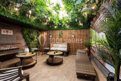 Couloir étroit avec sol en marbre, portant métallique, cintres en bois et étagères au fond sous un éclairage tamisé.