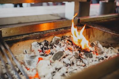 Salle de bain moderne avec lavabo blanc, miroir rond éclairé, robinet noir et carrelage mural texturé.