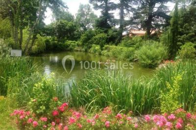 Intérieur d'une tente de réception avec tables rondes décorées, chaises en bois clair et lumière naturelle.