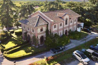 Intérieur d'une tente de réception avec tables rondes décorées, chaises en bois clair et lumière naturelle.