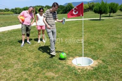 Salle de réception décorée pour un mariage, avec des tables alignées et nappes blanches ornées de nœuds roses.