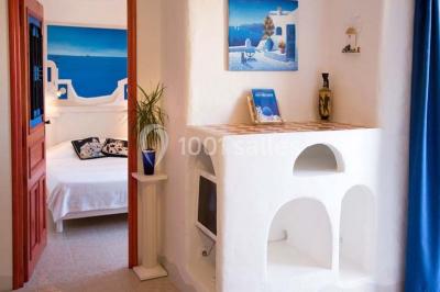 Salle de réception décorée pour un mariage, avec des tables alignées et nappes blanches ornées de nœuds roses.