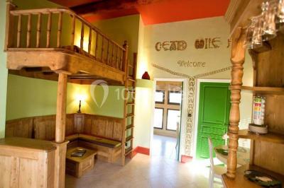 Salle de réception décorée pour un mariage, avec des tables alignées et nappes blanches ornées de nœuds roses.