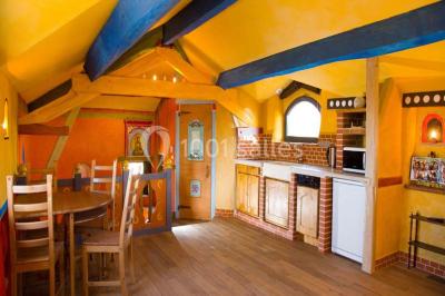 Salle de réception décorée pour un mariage, avec des tables alignées et nappes blanches ornées de nœuds roses.
