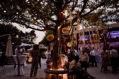Salle de réception décorée pour un mariage, avec des tables alignées et nappes blanches ornées de nœuds roses.