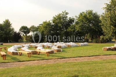 Un grand groupe de personnes posant ensemble en extérieur, devant un paysage verdoyant avec des arbres.