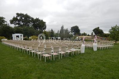 Un grand groupe de personnes posant ensemble en extérieur, devant un paysage verdoyant avec des arbres.