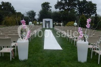Un grand groupe de personnes posant ensemble en extérieur, devant un paysage verdoyant avec des arbres.
