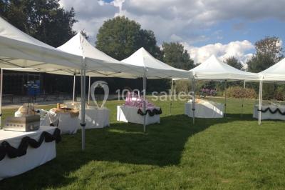 Un grand groupe de personnes posant ensemble en extérieur, devant un paysage verdoyant avec des arbres.