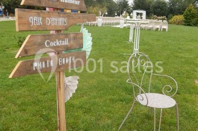 Un grand groupe de personnes posant ensemble en extérieur, devant un paysage verdoyant avec des arbres.