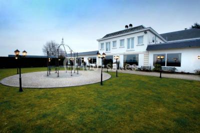 Fleurs blanches posées sur une table en bois, avec un fond flou de lumières et de décorations.