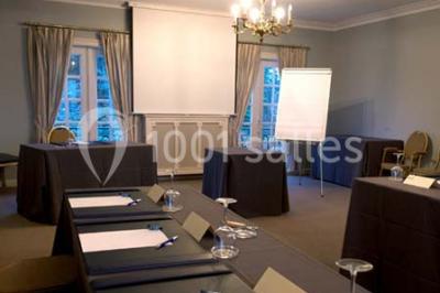 Fleurs blanches posées sur une table en bois, avec un fond flou de lumières et de décorations.