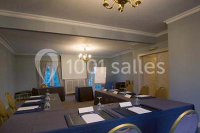 Fleurs blanches posées sur une table en bois, avec un fond flou de lumières et de décorations.