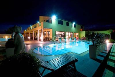 Vue d'une maison moderne avec piscine, statue décorative au premier plan et ciel dégagé en arrière-plan.