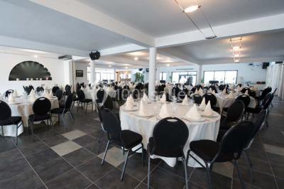 Vue d'une maison moderne avec piscine, statue décorative au premier plan et ciel dégagé en arrière-plan.
