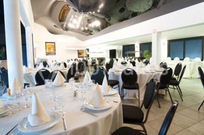 Vue d'une maison moderne avec piscine, statue décorative au premier plan et ciel dégagé en arrière-plan.