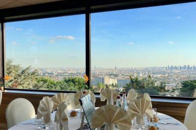 Vue panoramique d'une ville avec la tour Eiffel à gauche et des gratte-ciels modernes à droite sous un ciel dégagé.