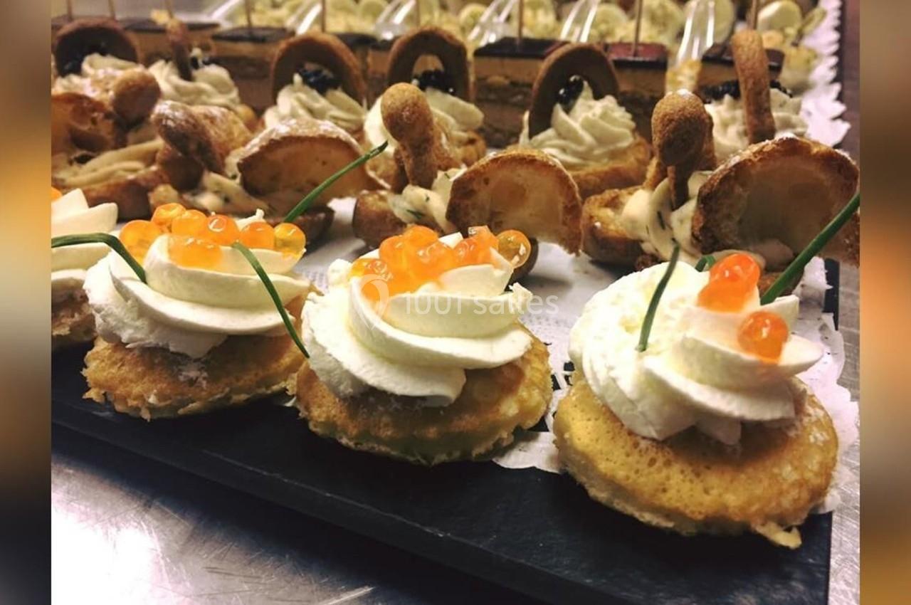 Assortiment de canapés garnis de crème, œufs de poisson et ciboulette, disposés sur un plateau.