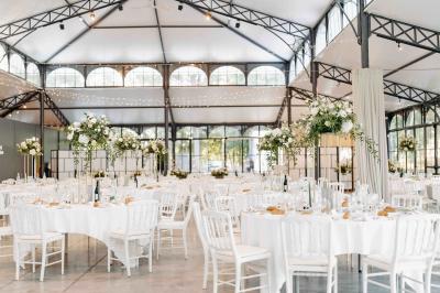Plaque ’Château de Champvallins’ sur une table en rotin avec une cloche dorée et une boîte décorative.