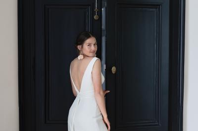 Plaque ’Château de Champvallins’ sur une table en rotin avec une cloche dorée et une boîte décorative.