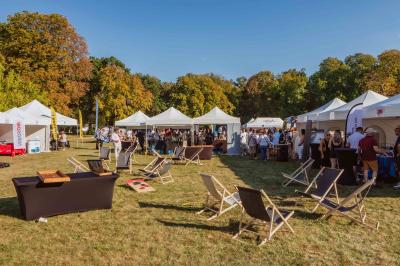 Plaque ’Château de Champvallins’ sur une table en rotin avec une cloche dorée et une boîte décorative.
