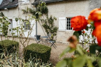 Plaque ’Château de Champvallins’ sur une table en rotin avec une cloche dorée et une boîte décorative.