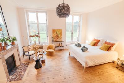 Plaque ’Château de Champvallins’ sur une table en rotin avec une cloche dorée et une boîte décorative.