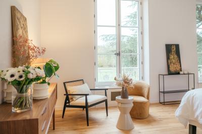 Plaque ’Château de Champvallins’ sur une table en rotin avec une cloche dorée et une boîte décorative.