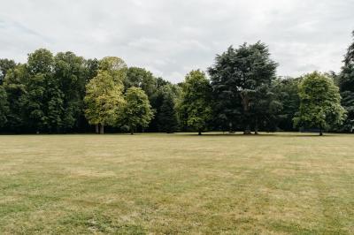 Plaque ’Château de Champvallins’ sur une table en rotin avec une cloche dorée et une boîte décorative.