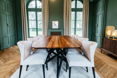 Plaque ’Château de Champvallins’ sur une table en rotin avec une cloche dorée et une boîte décorative.