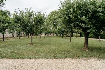 Plaque ’Château de Champvallins’ sur une table en rotin avec une cloche dorée et une boîte décorative.