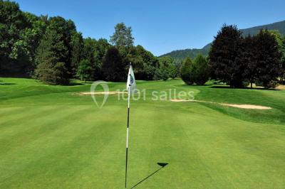 Salle de restaurant élégante avec grandes baies vitrées, tables dressées et luminaires suspendus au plafond.