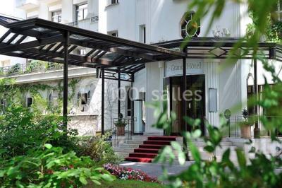Salle de restaurant élégante avec grandes baies vitrées, tables dressées et luminaires suspendus au plafond.