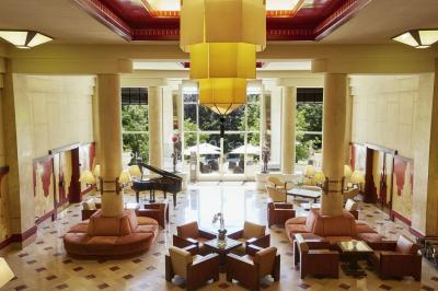 Salle de restaurant élégante avec grandes baies vitrées, tables dressées et luminaires suspendus au plafond.