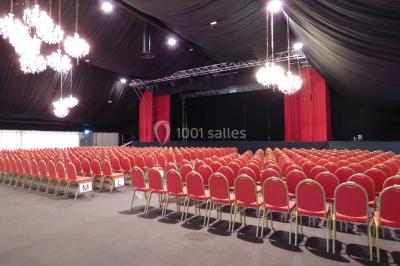 Salle de restaurant élégante avec grandes baies vitrées, tables dressées et luminaires suspendus au plafond.