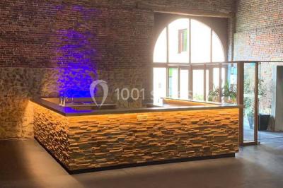 Groupe de personnes discutant dans un jardin sous des parasols, avec des tables hautes recouvertes de nappes noires.