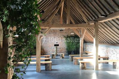 Groupe de personnes discutant dans un jardin sous des parasols, avec des tables hautes recouvertes de nappes noires.