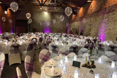 Groupe de personnes discutant dans un jardin sous des parasols, avec des tables hautes recouvertes de nappes noires.