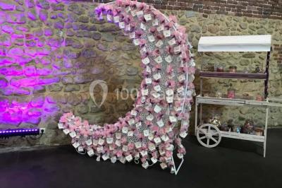 Groupe de personnes discutant dans un jardin sous des parasols, avec des tables hautes recouvertes de nappes noires.