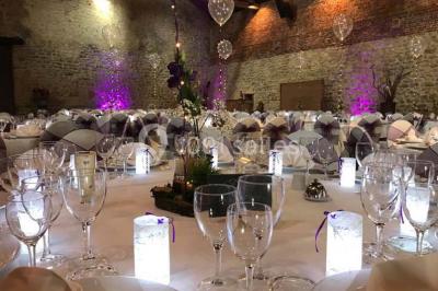 Groupe de personnes discutant dans un jardin sous des parasols, avec des tables hautes recouvertes de nappes noires.