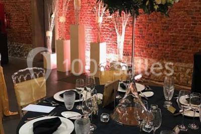 Groupe de personnes discutant dans un jardin sous des parasols, avec des tables hautes recouvertes de nappes noires.