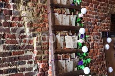 Groupe de personnes discutant dans un jardin sous des parasols, avec des tables hautes recouvertes de nappes noires.