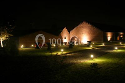 Groupe de personnes discutant dans un jardin sous des parasols, avec des tables hautes recouvertes de nappes noires.