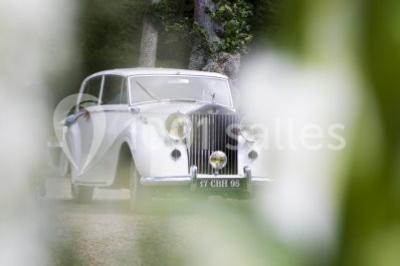 Un parc de nuit avec des arbres sombres, une structure lumineuse orange et des chemins faiblement éclairés.